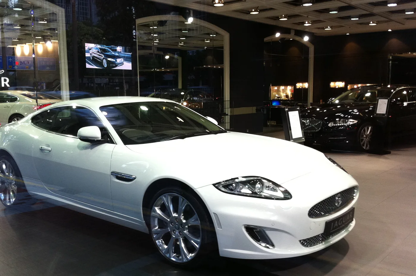 A car dealership showroom, each vehicle listing backed by a unique Callr tracked number